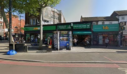 Street-level view of a Subway shopfront on a high street, neighbouring shops visible either side.